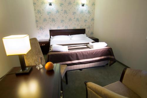 a hotel room with a bed and a table with a lamp at Belle Royalle in Lisarnya