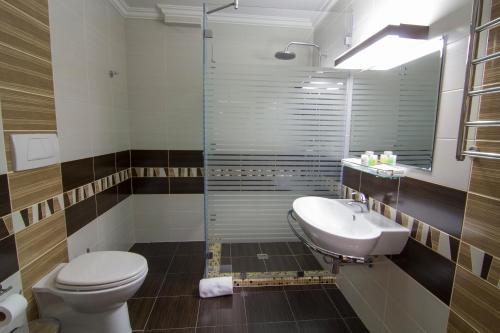 a bathroom with a toilet and a sink and a shower at Belle Royalle in Lisarnya