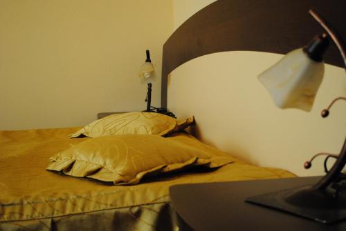 a bedroom with a bed with a lamp and two pillows at Casa Amurg in Sinaia