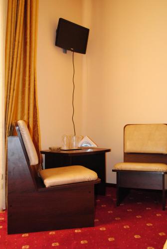 a room with a chair and a table and a television at Casa Amurg in Sinaia