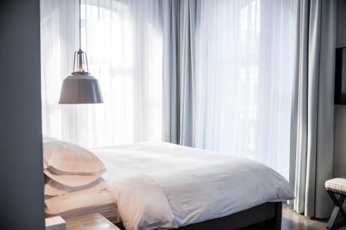 a bedroom with a white bed and a window at Hotel Oui GO! in Trois-Rivières