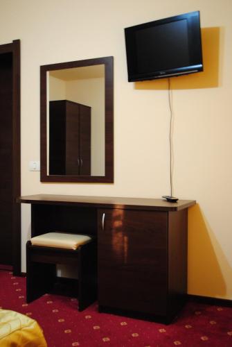 a room with a dresser with a mirror and a tv at Casa Amurg in Sinaia