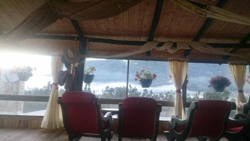 a room with chairs in front of a large window at Rancho Carrizal in Iza