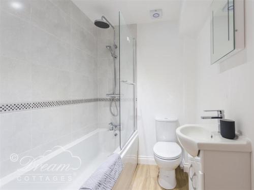 een witte badkamer met een toilet en een wastafel bij Markham Cottage in Weymouth