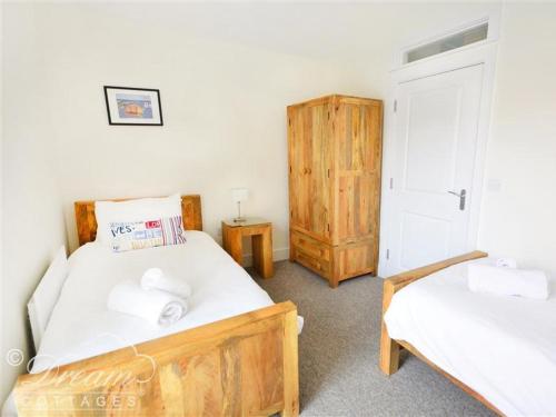um quarto com 2 camas e um armário de madeira em Olympic Cottage em Portland