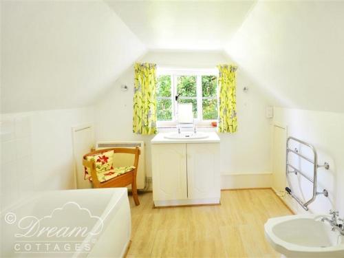 a white bathroom with a sink and a sinkessment at Little Berwick Cottage in Burton Bradstock