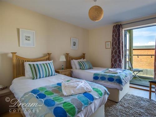 a bedroom with two beds and a window with a view at Harbour View Apartment in West Bay