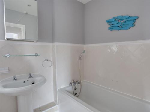 ウェイマスにあるMarina Vistaの洗面台とシャワー付きの白いバスルーム