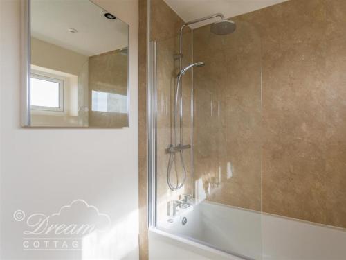 a bathroom with a shower with a glass door at Seacliff in West Bay