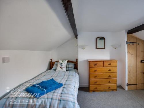 a bedroom with a bed and a wooden dresser at Driftwood in Weymouth