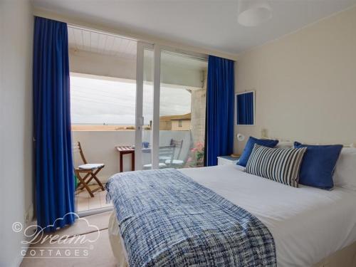 a bedroom with a large bed with blue curtains at Jurassic View in West Bay