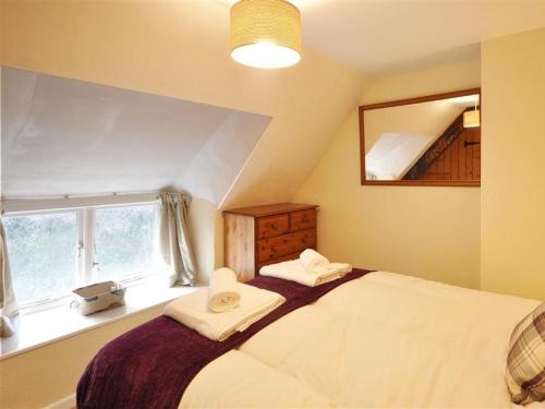 Un dormitorio con una cama grande y una ventana en Little Ivy en West Lulworth