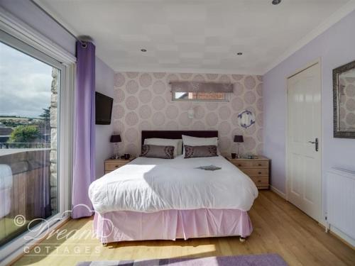 a bedroom with a large bed and a large window at Bowleaze View in Weymouth