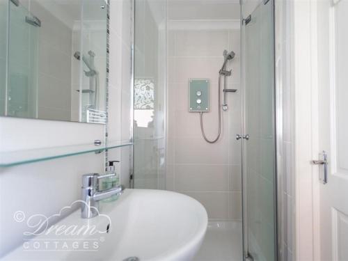 ein weißes Badezimmer mit Dusche und Waschbecken in der Unterkunft Bowleaze View in Weymouth