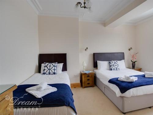 a bedroom with two beds with towels on them at Beach View Apartment 3 in Weymouth