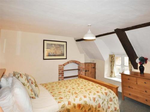 a bedroom with a bed and a wooden dresser at Ivy Cottage in West Lulworth
