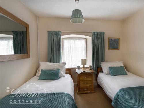 um quarto com 2 camas e uma janela em Tavern Way em Corfe Castle