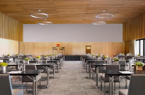 a dining room with tables and chairs and a large screen at Montage Los Cabos in Cabo San Lucas