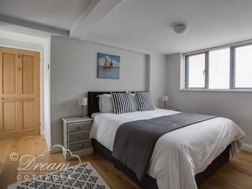 韋茅斯的住宿－Waterside，一间卧室设有一张大床和一个窗户。