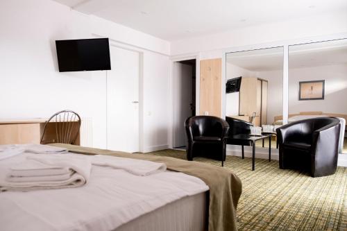 ブカレストにあるCasa Gabrielaのベッド1台と椅子2脚が備わるホテルルームです。