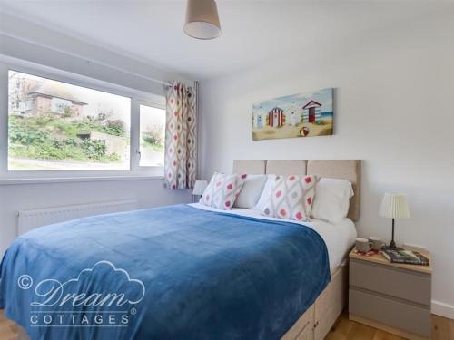 a bedroom with a large bed with a blue blanket at Seacliff in West Bay