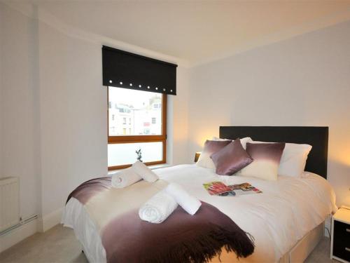 a bedroom with a large bed with towels on it at Old Harbour View in Weymouth