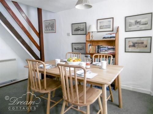 a dining room table with chairs and a bowl of fruit on it at Tavern Way in Corfe Castle