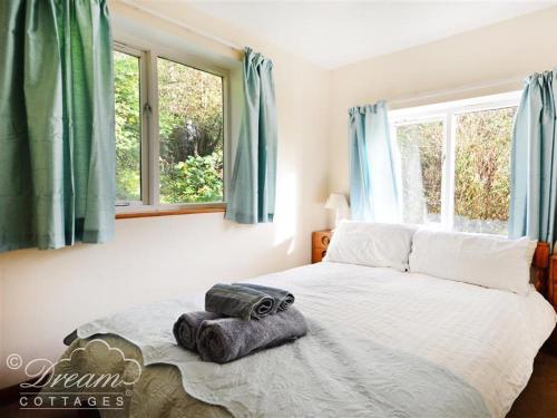 A bed or beds in a room at Whispering Pines Cottage