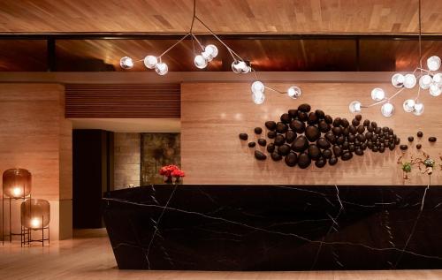 a lobby with a black counter and some lights at Montage Los Cabos in Cabo San Lucas