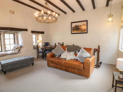 ein Wohnzimmer mit einem Sofa und einem Tisch in der Unterkunft Farriers Cottage in Matlock