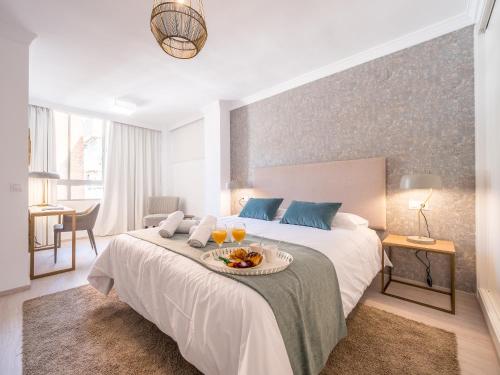 Un dormitorio con una cama con una bandeja de comida. en MALAGUETA SEA VIEW - PREMIUM APARTMENT, en Málaga