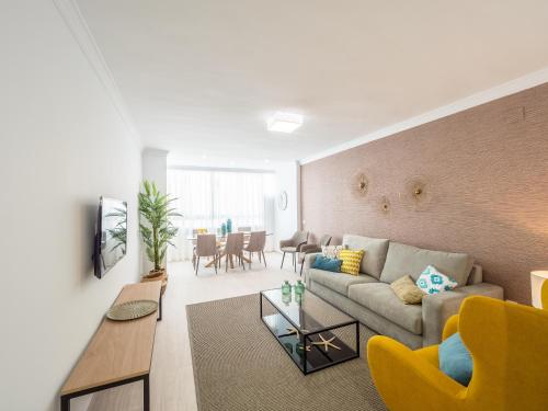 a living room with a couch and a table at MALAGUETA SEA VIEW - PREMIUM APARTMENT in Málaga