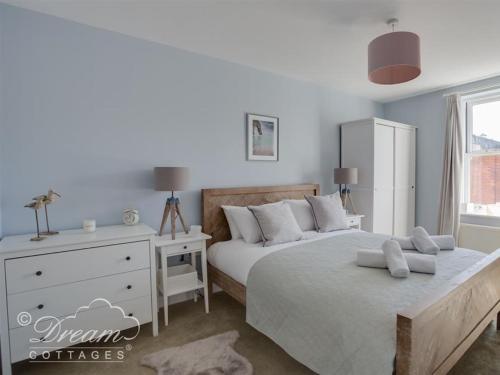 ウェイマスにあるMarina Vistaのベッド2台とドレッサーのある寝室