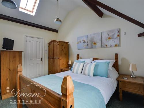 ein Schlafzimmer mit großem Bett und Fernseher in der Unterkunft Rupert Cottage in Weymouth