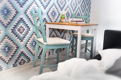 a dining room table with two chairs and a table with a wall at Pod Wodospadem in Szczyrk
