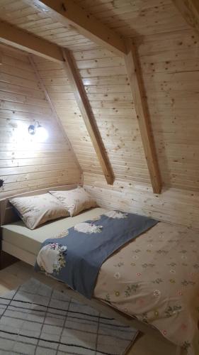 a bed in the attic of a wooden house at Vile Stefan in Zaovine