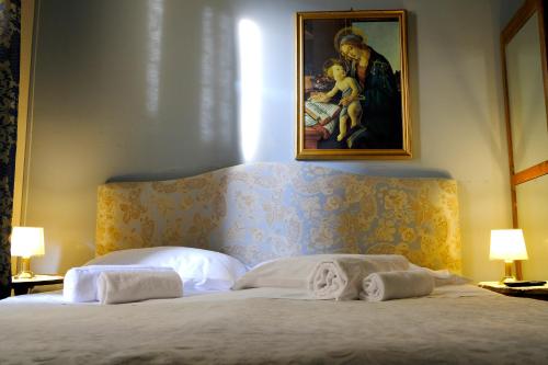 a bedroom with a bed with a painting on the wall at Al Tuscany B&B in Lucca