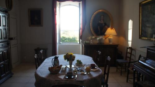 - une salle à manger avec une table et des fleurs dans l'établissement Domaine de Lamartine, à Pont-Saint-Esprit