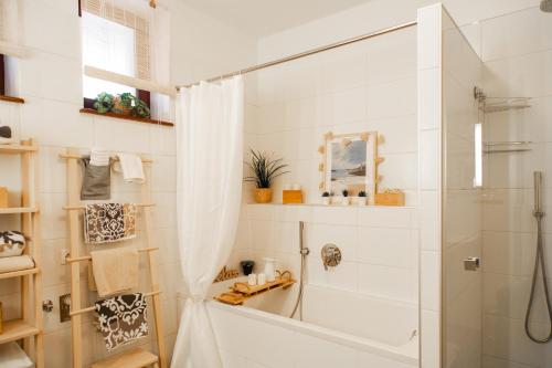 een witte badkamer met een douche en een bad bij Apartmán NINA in Veľká Lomnica
