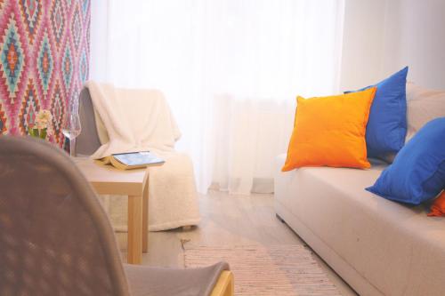 a living room with a couch with colorful pillows on it at Pod Wodospadem in Szczyrk