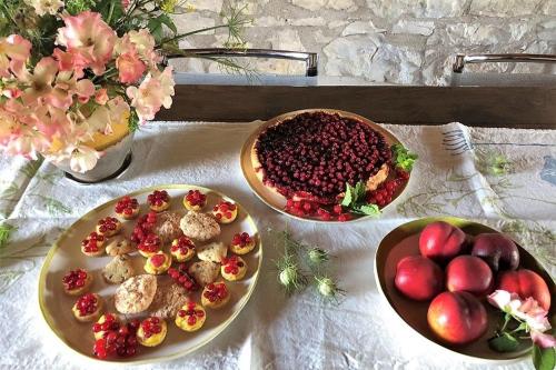 a table with two plates of food and a bowl of fruit at Agriturismo Podere Prasiano in Marano sul Panaro