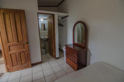 a bathroom with a wooden dresser and a mirror at Casa Kibi Kibi in San José