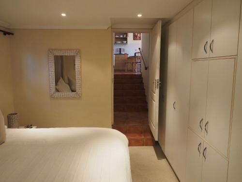 a bedroom with a bed and a hallway with a mirror at Swallow's Nest in Somerset West