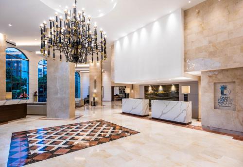 a lobby with a chandelier and a fireplace at Hotel Dann Carlton Bucaramanga in Bucaramanga