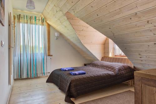 ドブレ・ミアストにあるRezydencja Limajnoの木製の部屋に大型ベッドが備わるベッドルーム1室が備わります。