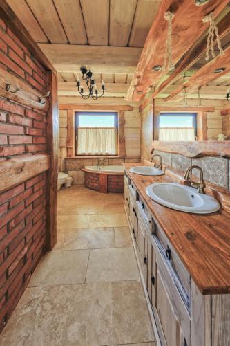 a bathroom with two sinks in a log cabin at Rezydencja Limajno in Dobre Miasto