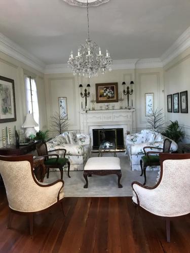 a living room filled with furniture and a chandelier at Springwood Inn in Anniston