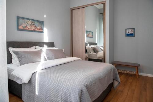 a bedroom with a bed with white sheets and a mirror at Charming apartment in the historic district of Tbilisi in Tbilisi City