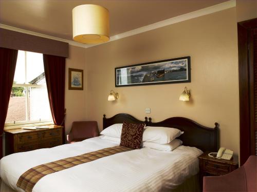 a hotel room with a bed and a phone at Duck's Inn in Aberlady