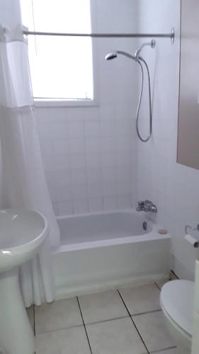 a white bathroom with a tub and a sink at Hotel Auberge Michel Doyon in Quebec City